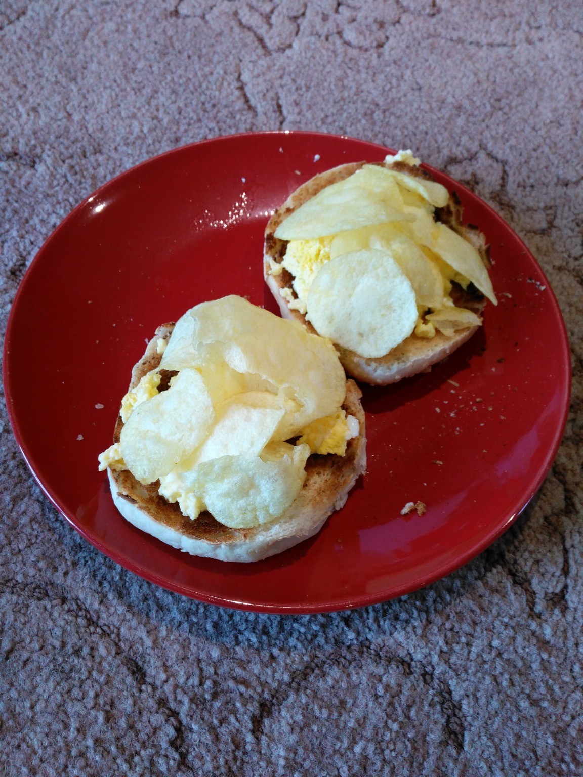 Toasted roll topped with crisps and scrambled egg