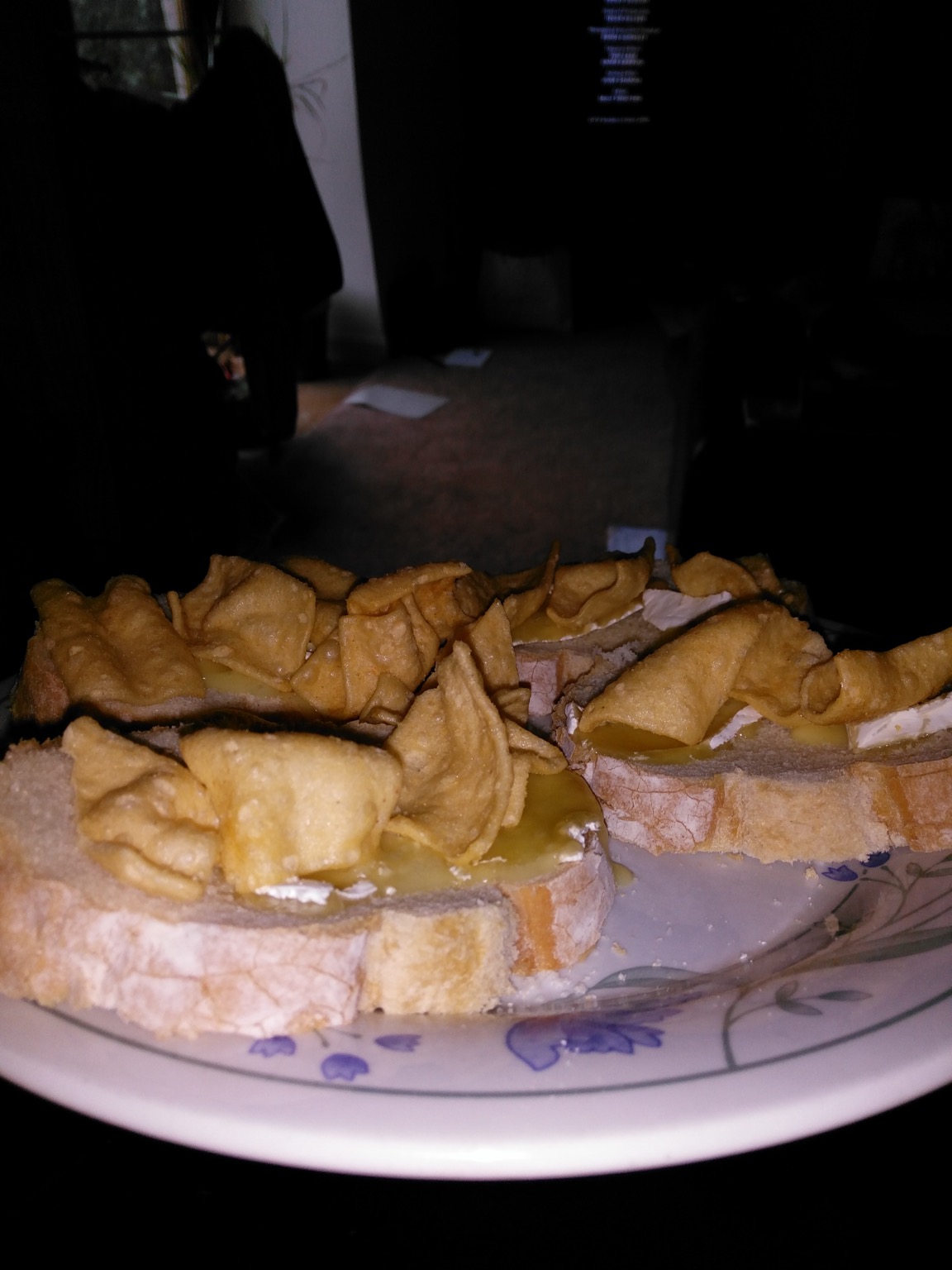 Flash photo of corn snacks and brie on sliced bread