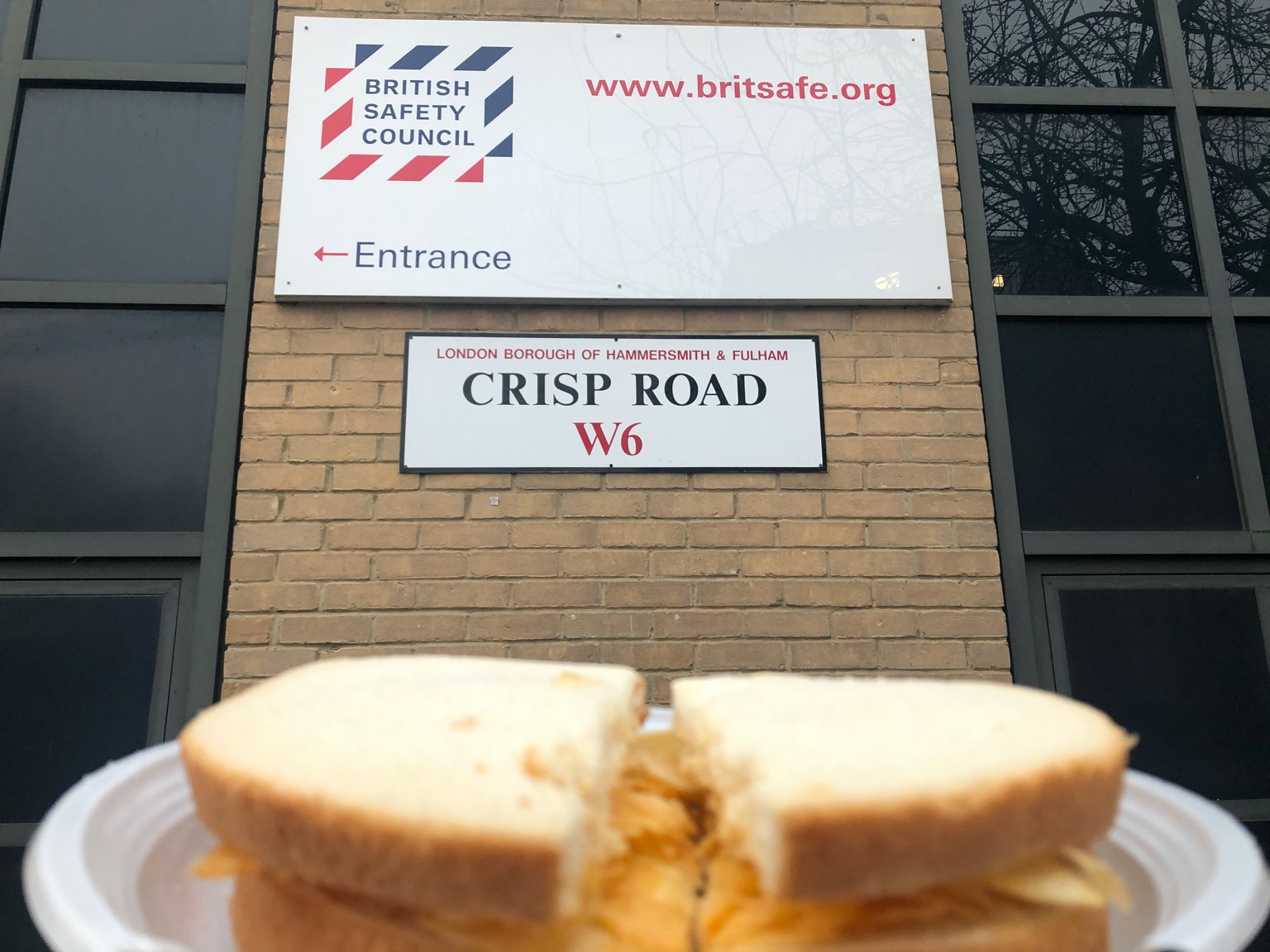 Crisp sandwich held up in front of Crisp Road sign