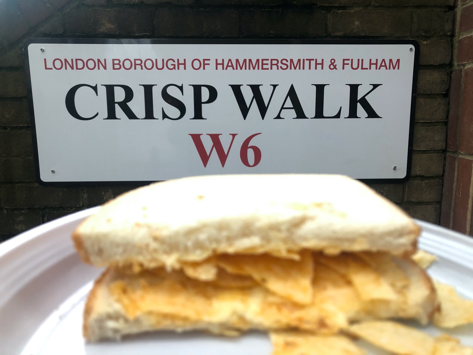 Half of a crisp sandwich in front of Crisp Walk sign