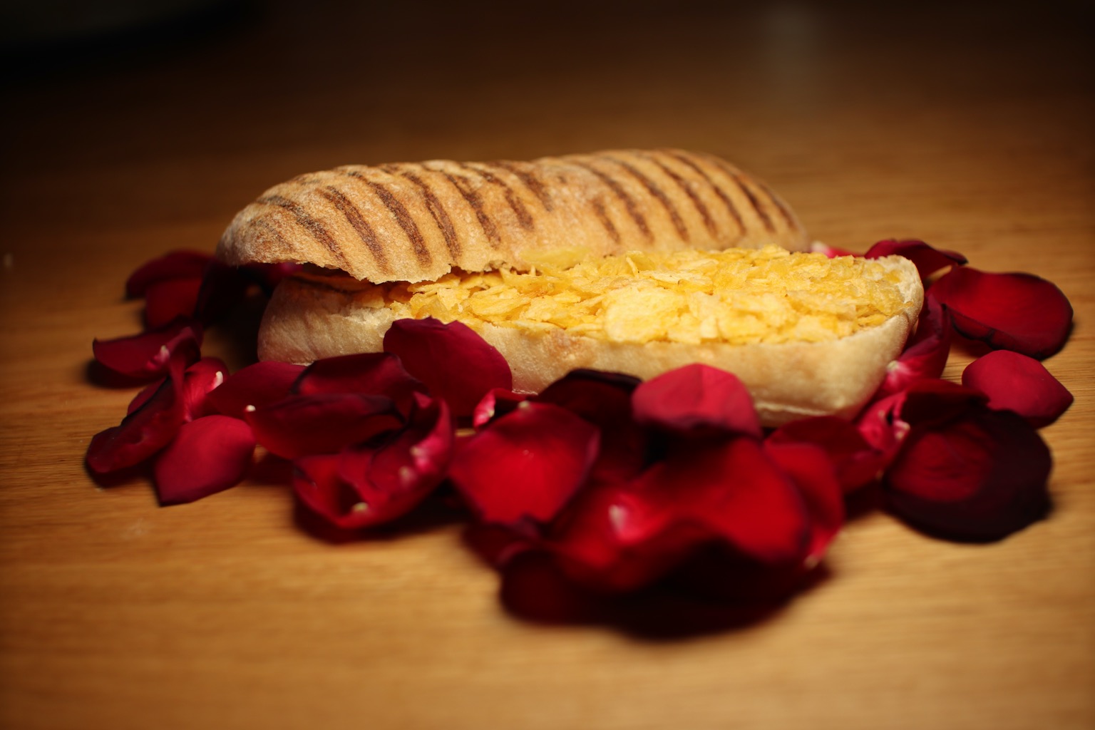 Crushed crisps in/on panini on a bed of petals