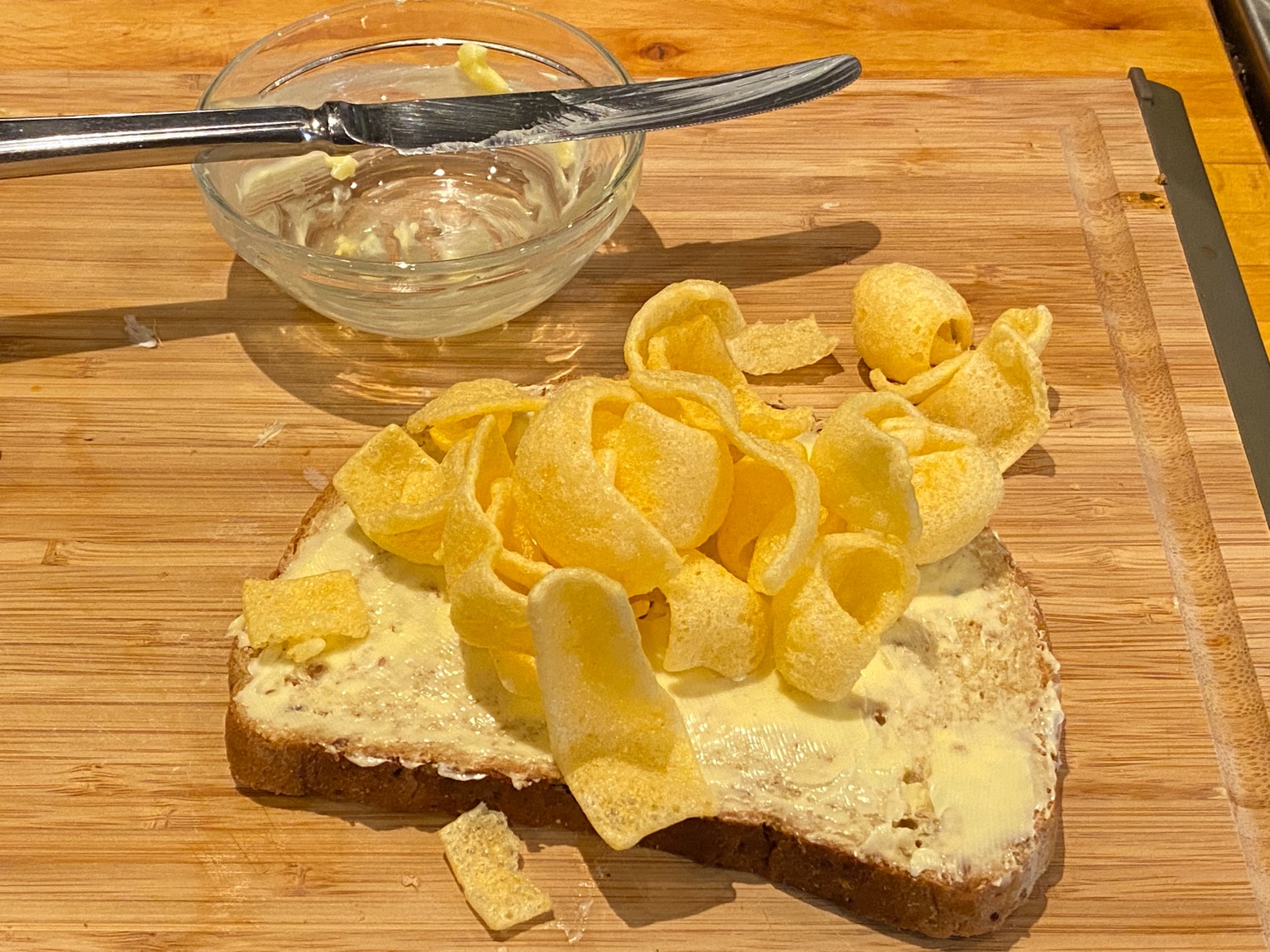 Quavers on brown bread alongside knife and dish