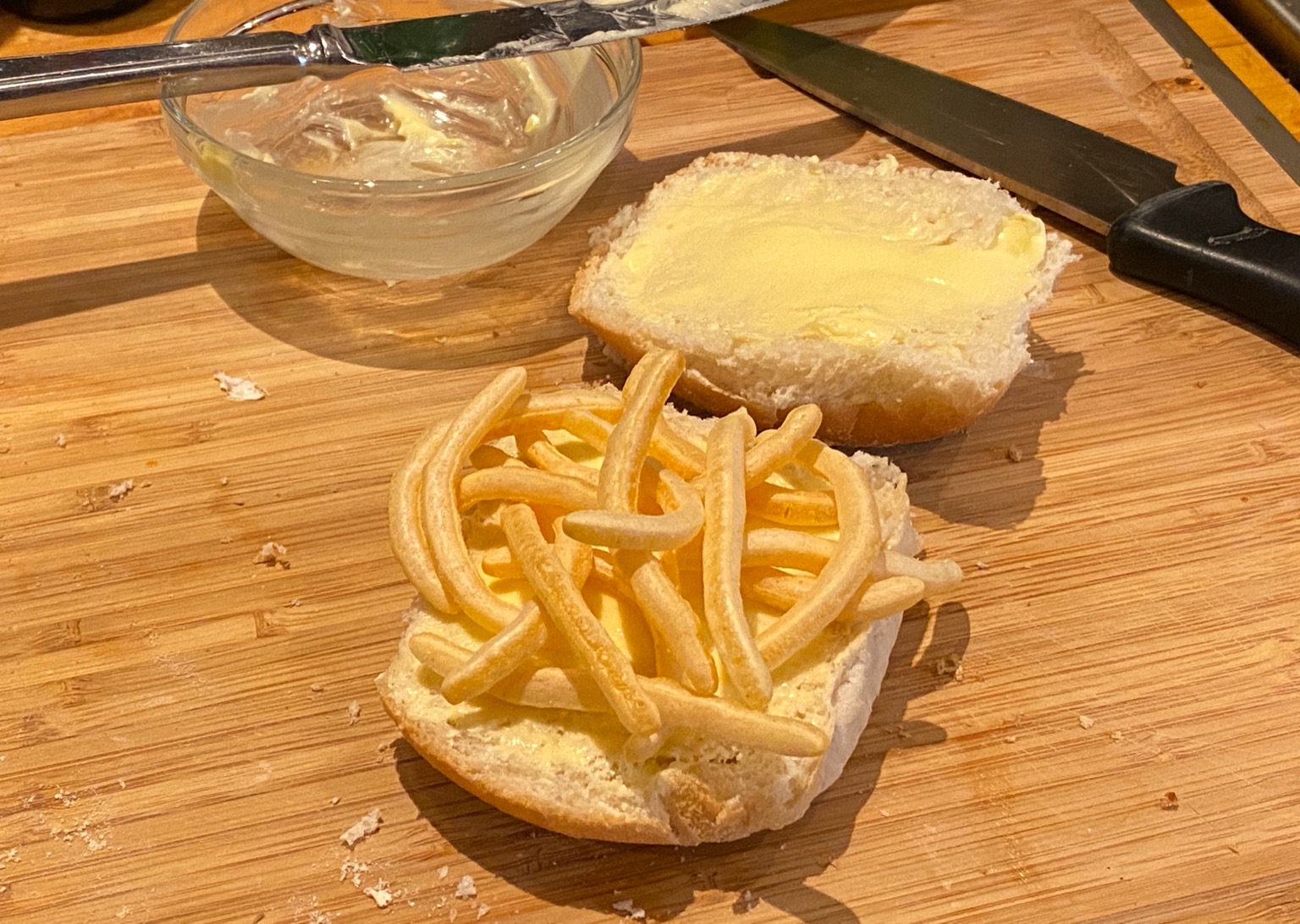 French Fries snacks on bread roll alongside knife