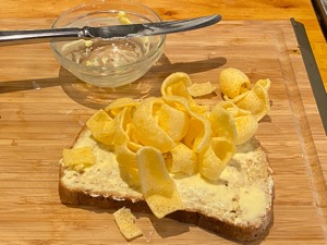 Quavers on brown bread alongside knife and dish