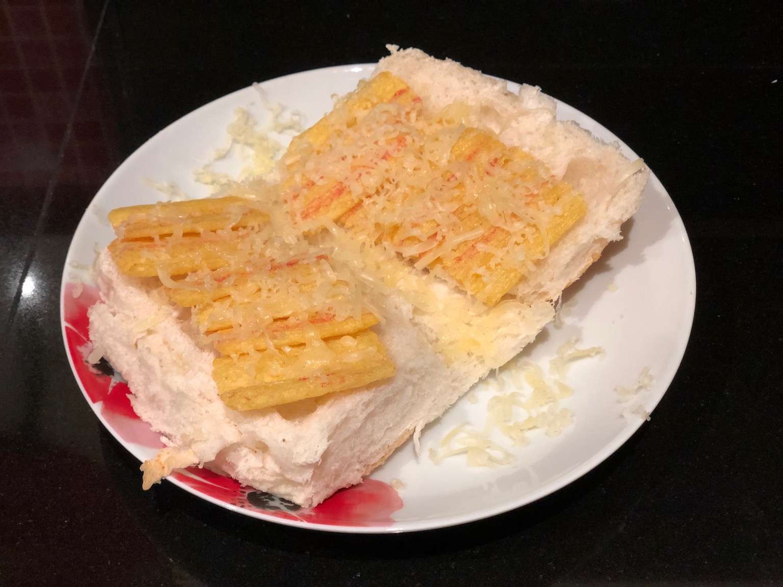 Frazzles and grated cheese on an open white roll