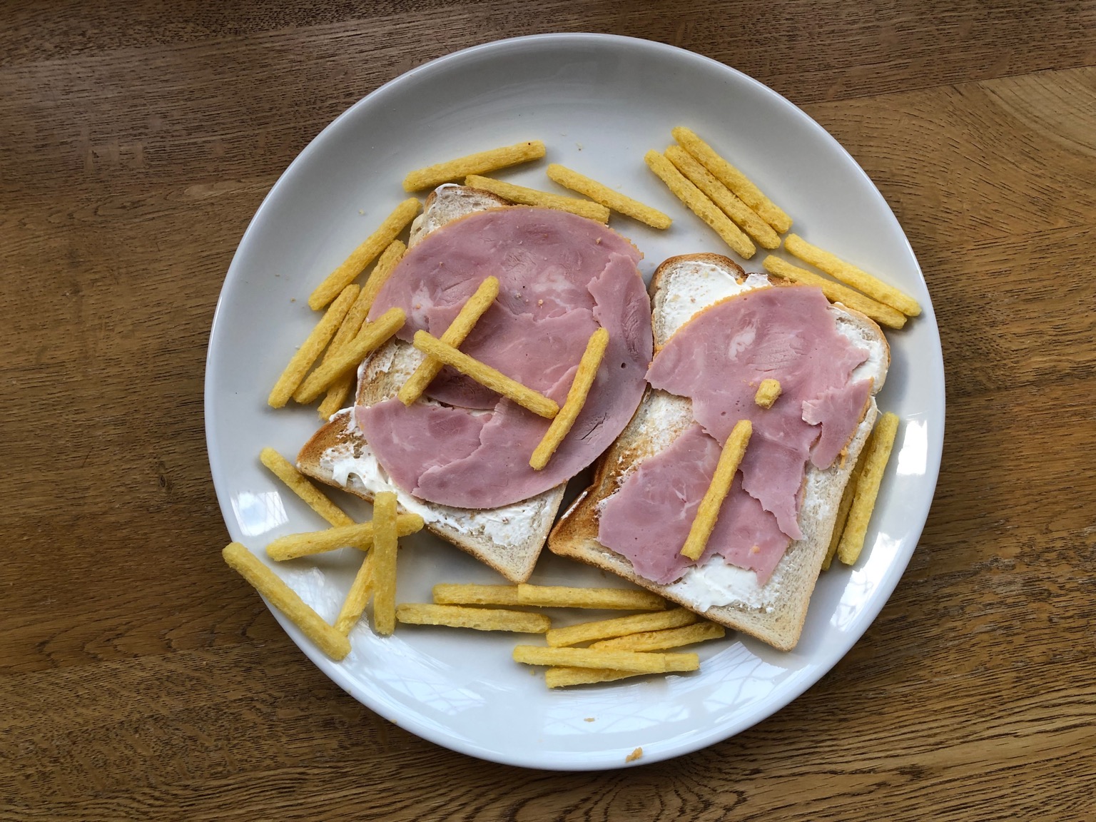 Chipsticks spelling "Hi" on ham on white toast