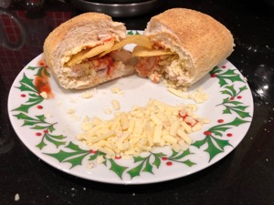 Crisps, cheese, meat and sauce in a sliced roll