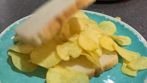 Lid dropped onto white crisp sandwich in slow motion