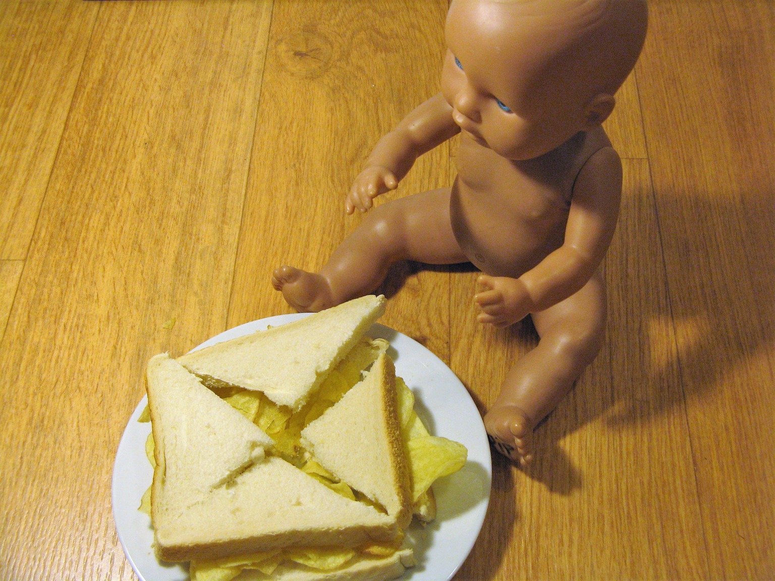 Quartered crisp sandwich alongside a doll