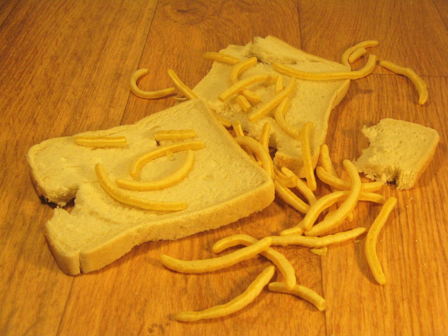 Torn white bread with scattered French Fries snacks