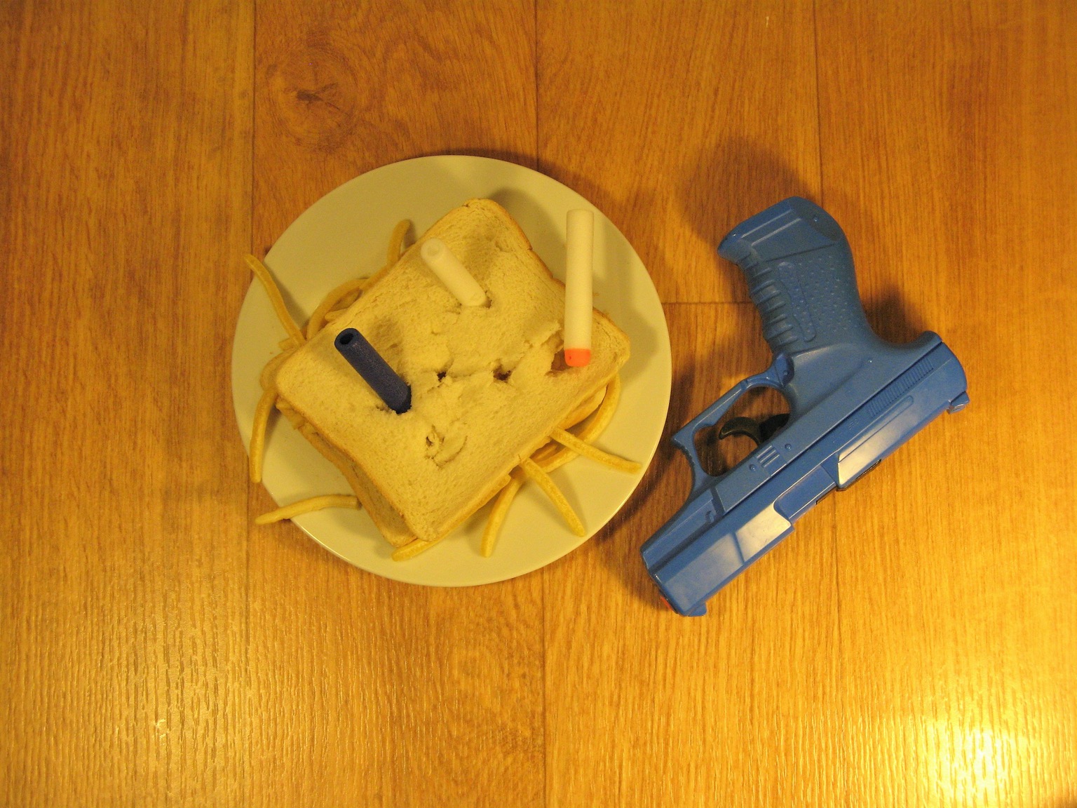 Sandwich of French Fries snacks shot by toy gun