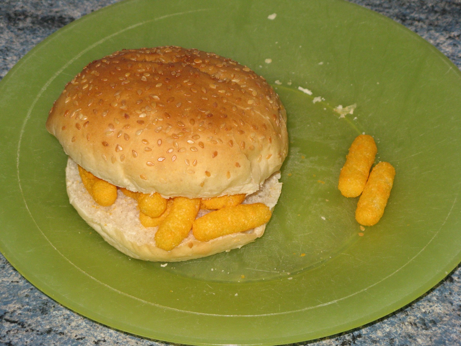 Wotsits in a sesame seed bun on a green plate