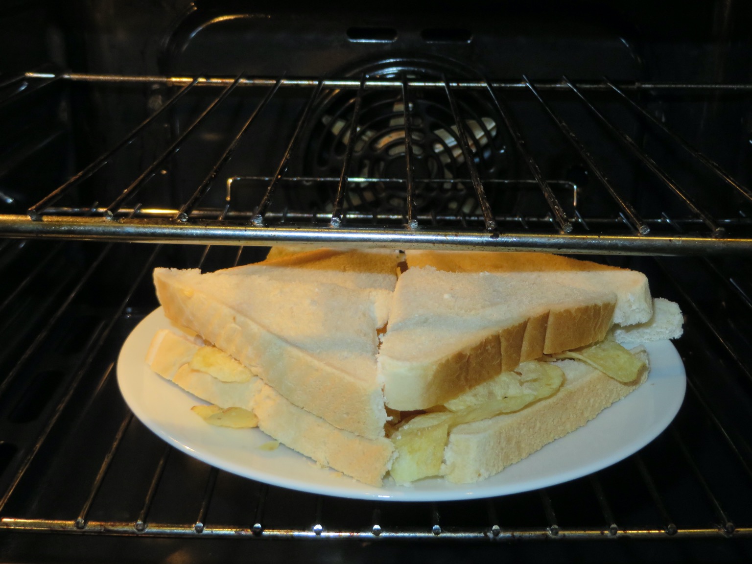 Quartered white crisp sandwich in an oven