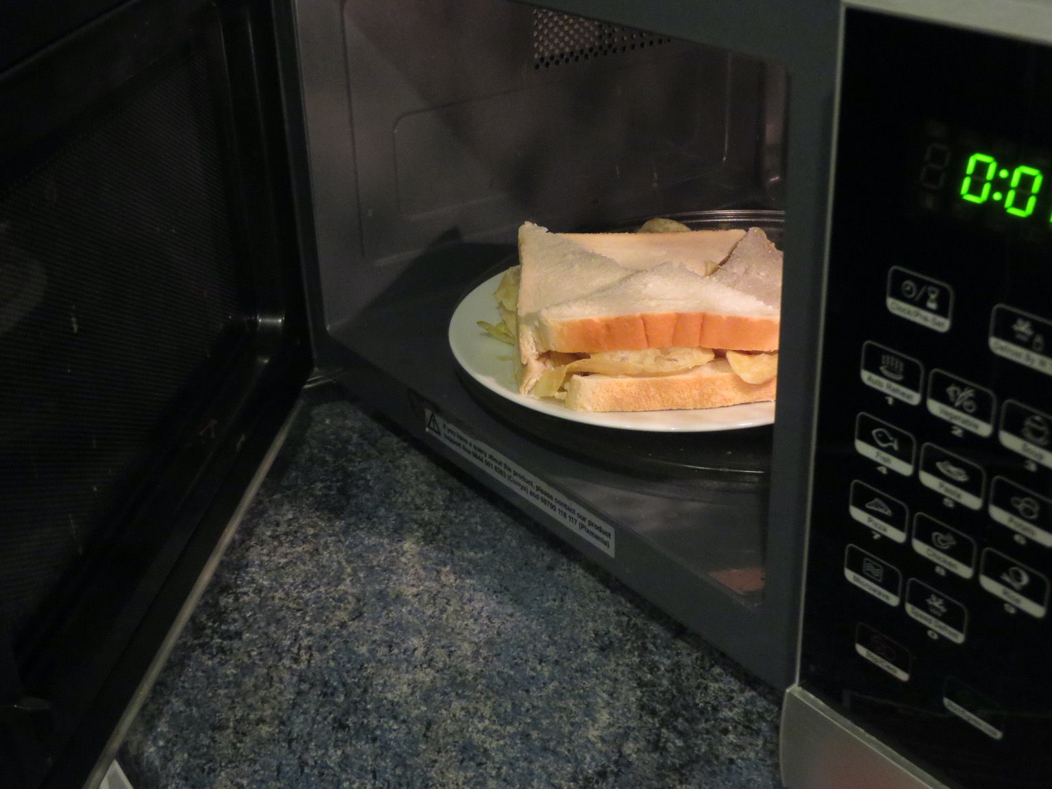 Quartered white crisp sandwich in a microwave
