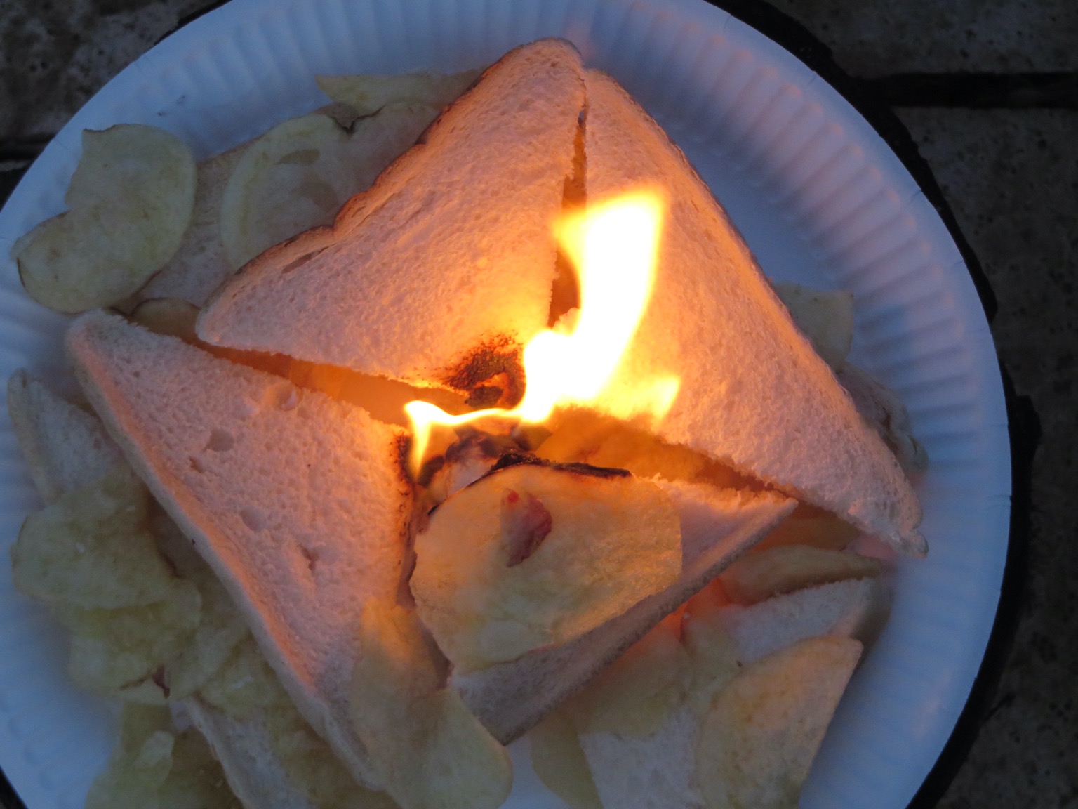 Burning crisp sandwich on a paper plate