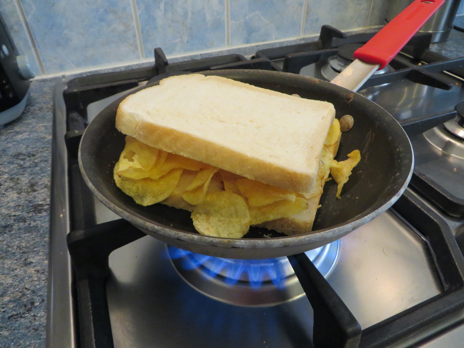 Crisp-filled white sandwich in a pan over flames