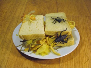 Halved sandwich covered with plastic insects