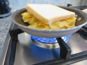 White crisp sandwich in a pan on a gas hob