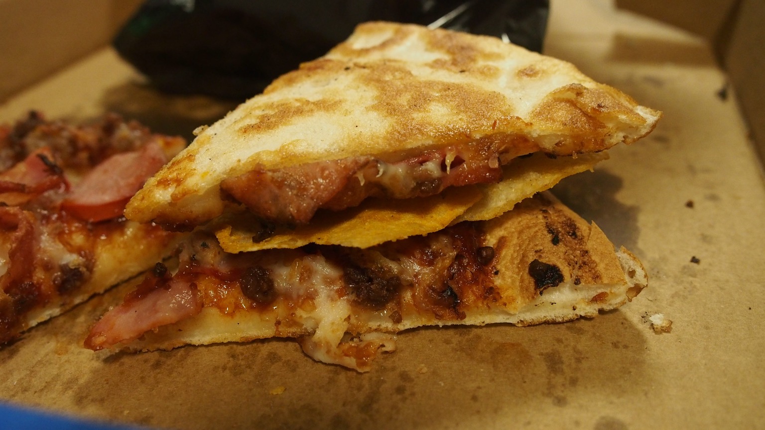 Close up of crisps sandwiched between pizza