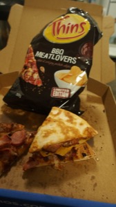 Pizza crisp sandwich alongside bag and more pizza