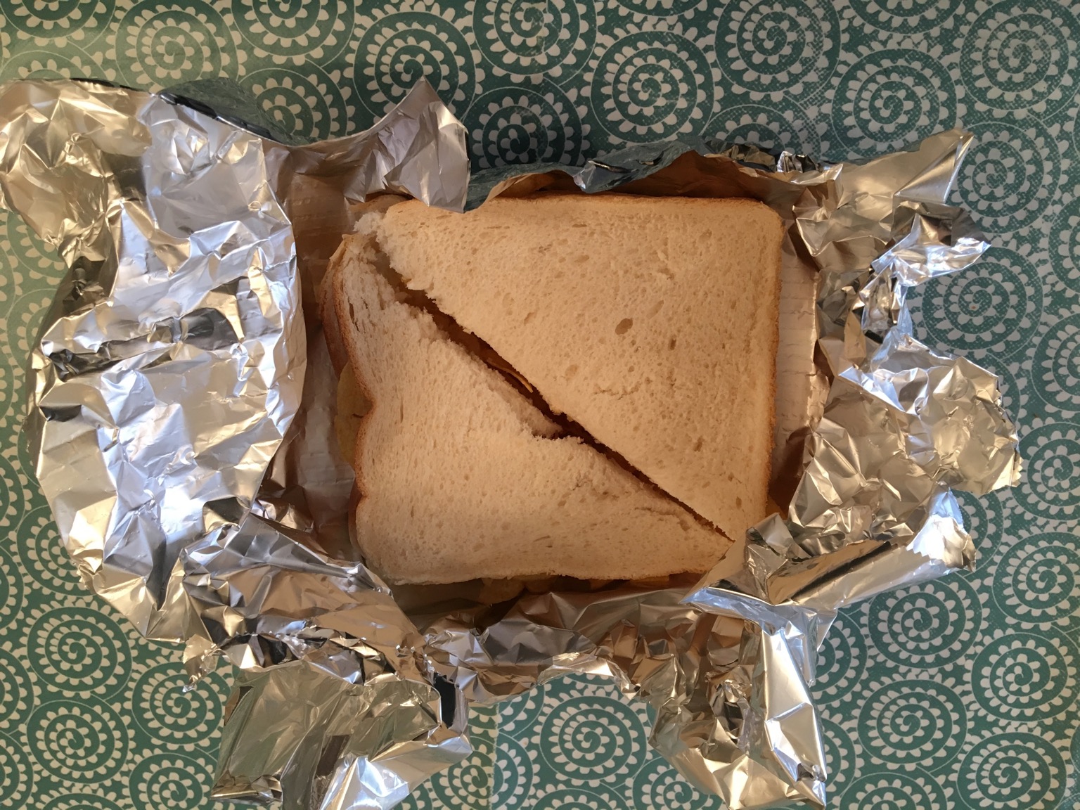 Overhead view of a crisp sandwich in foil