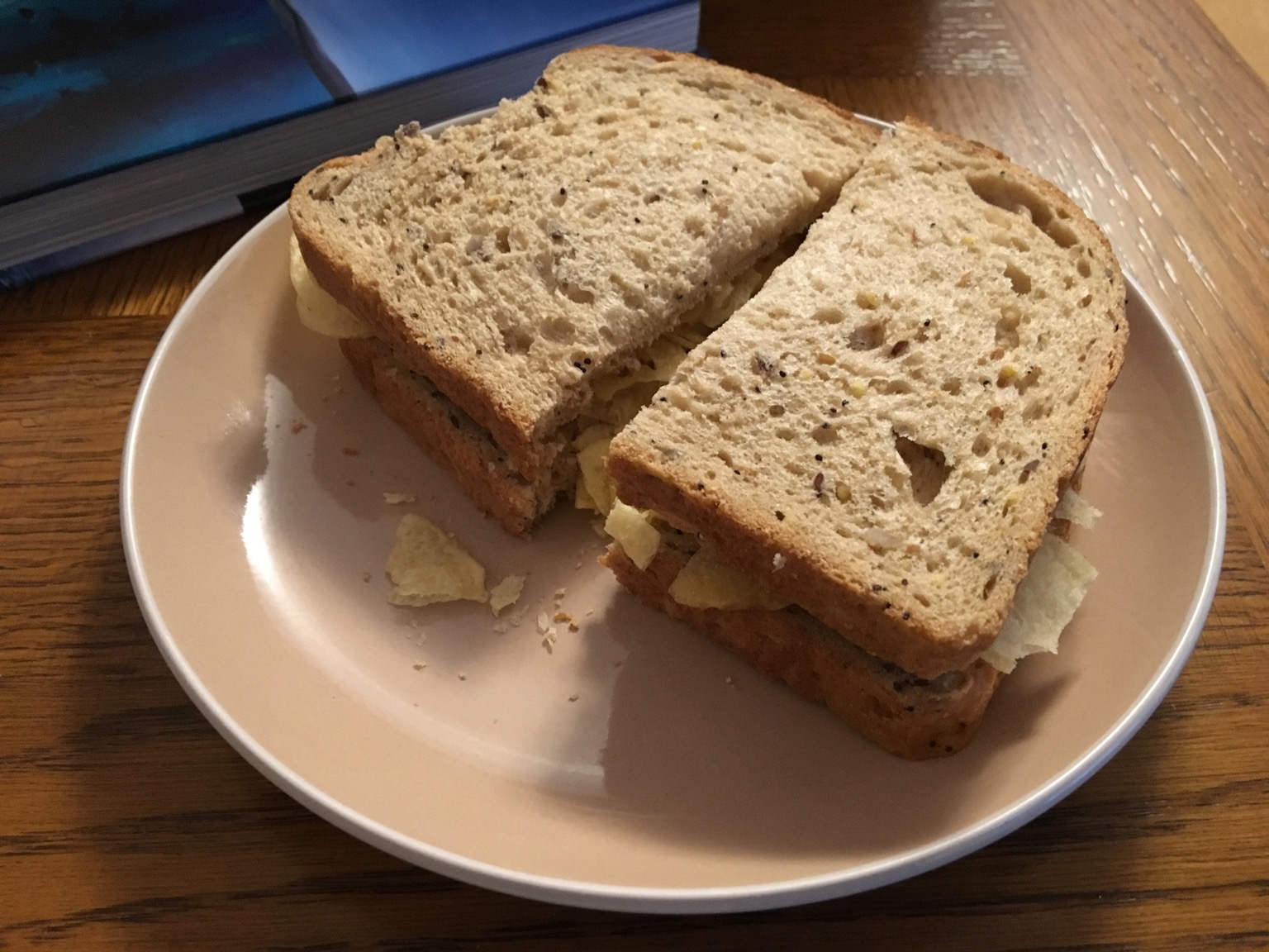 Halved brown crisp sandwich alongside a book