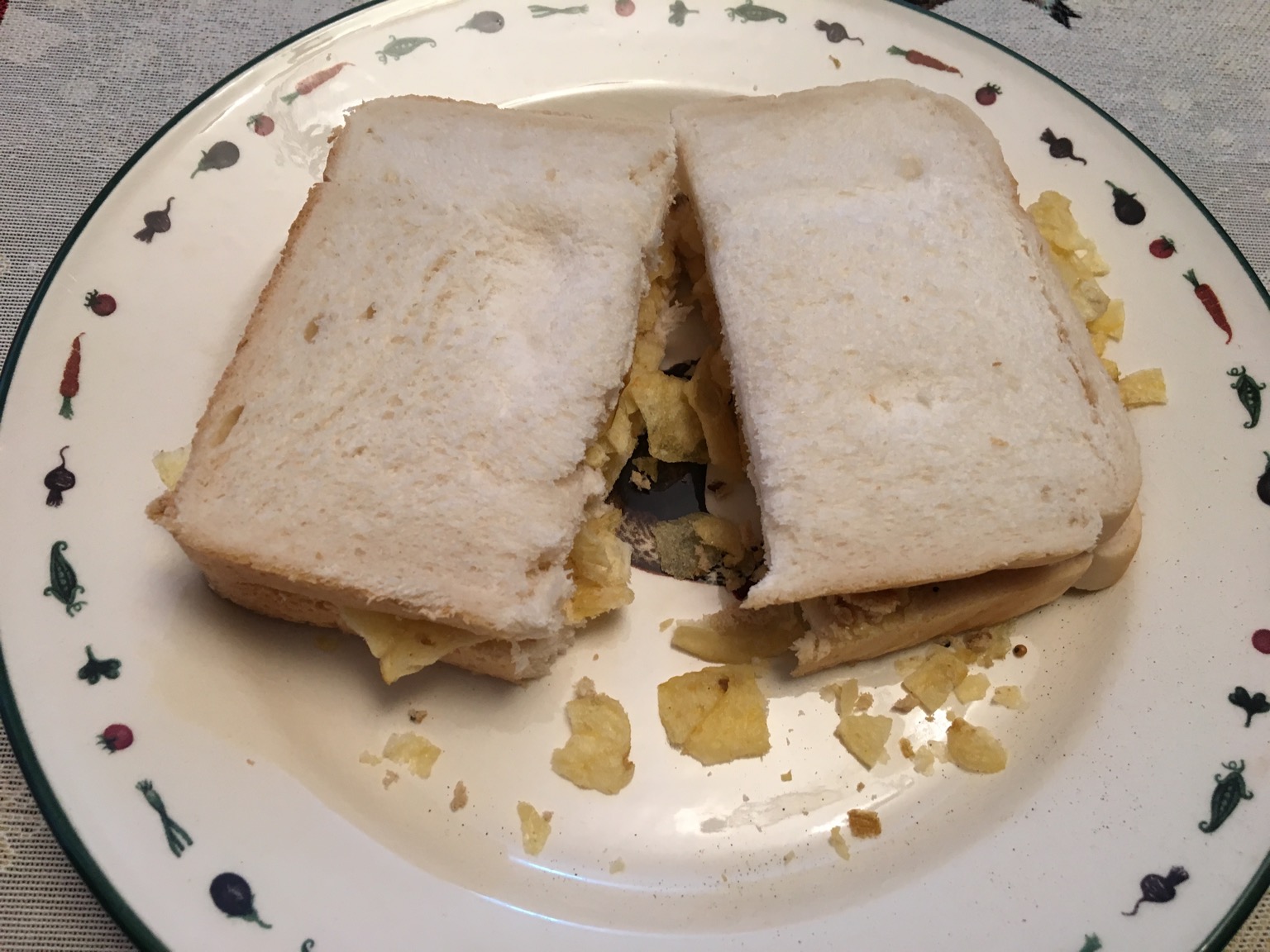 Sliced white bread containing crisps and cut in half