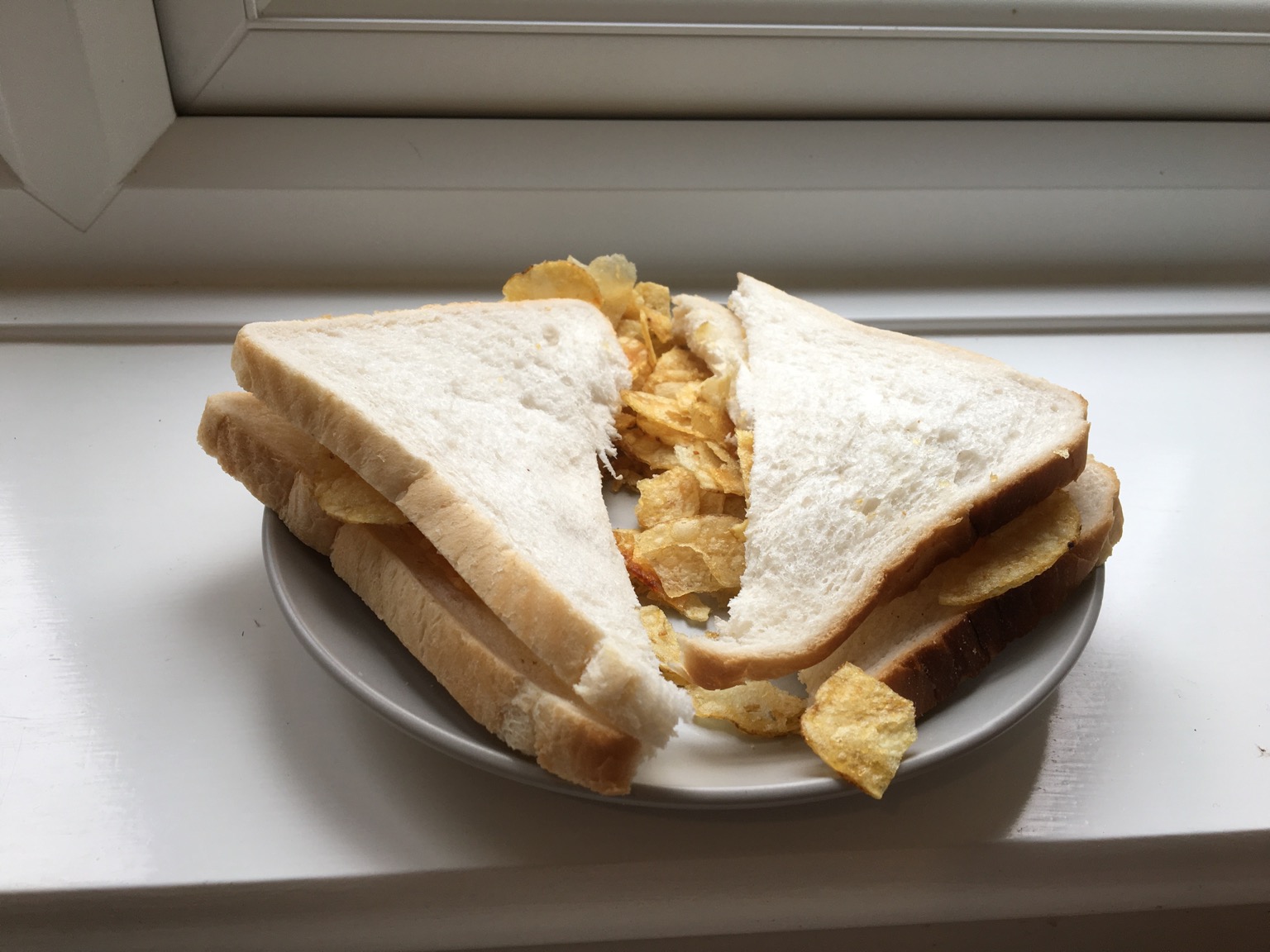Diagonally-cut crisp sandwich on a windowsill