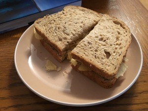 Halved brown crisp sandwich alongside a book